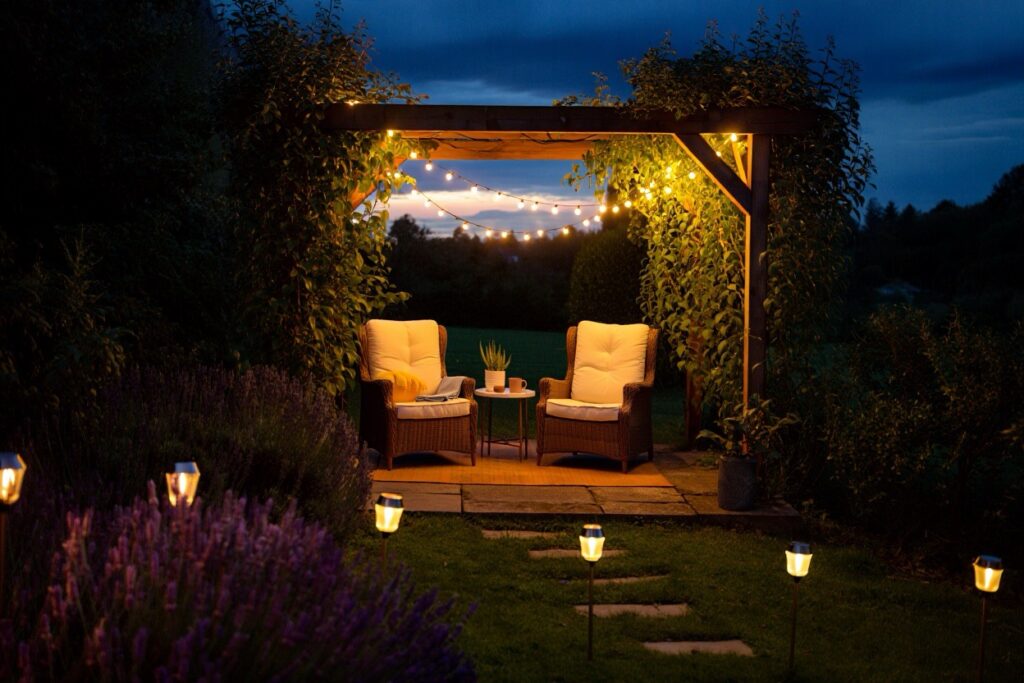 fauteuils de jardin confortables et lumières à la tombée de la nuit